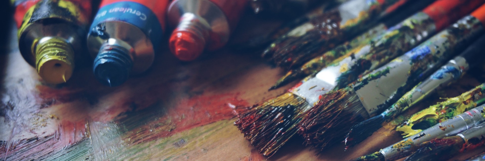 A rich pallette of freshly used paints and paintbrushes from a day of creating art